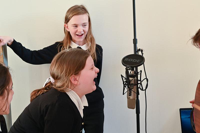 Pupils shouting into a hanging microphone